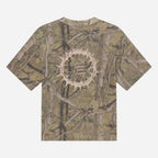 A short-sleeve t-shirt with an all-over woodland camouflage pattern in shades of brown, beige, and green. The center of the chest features a circular graphic design with a thorny crown of thorns motif and the text 'But the Lord loves righteousness' in a light beige font.