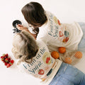 Two people wearing 'Fruit of the Spirit' hoodies with fruits printed on them, surrounded by fruits on a white background.