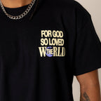 Black t-shirt with 'For God So Loved The World' text worn by a person.