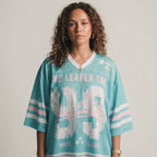 Person wearing a light blue sports jersey with text and graphics on a plain background