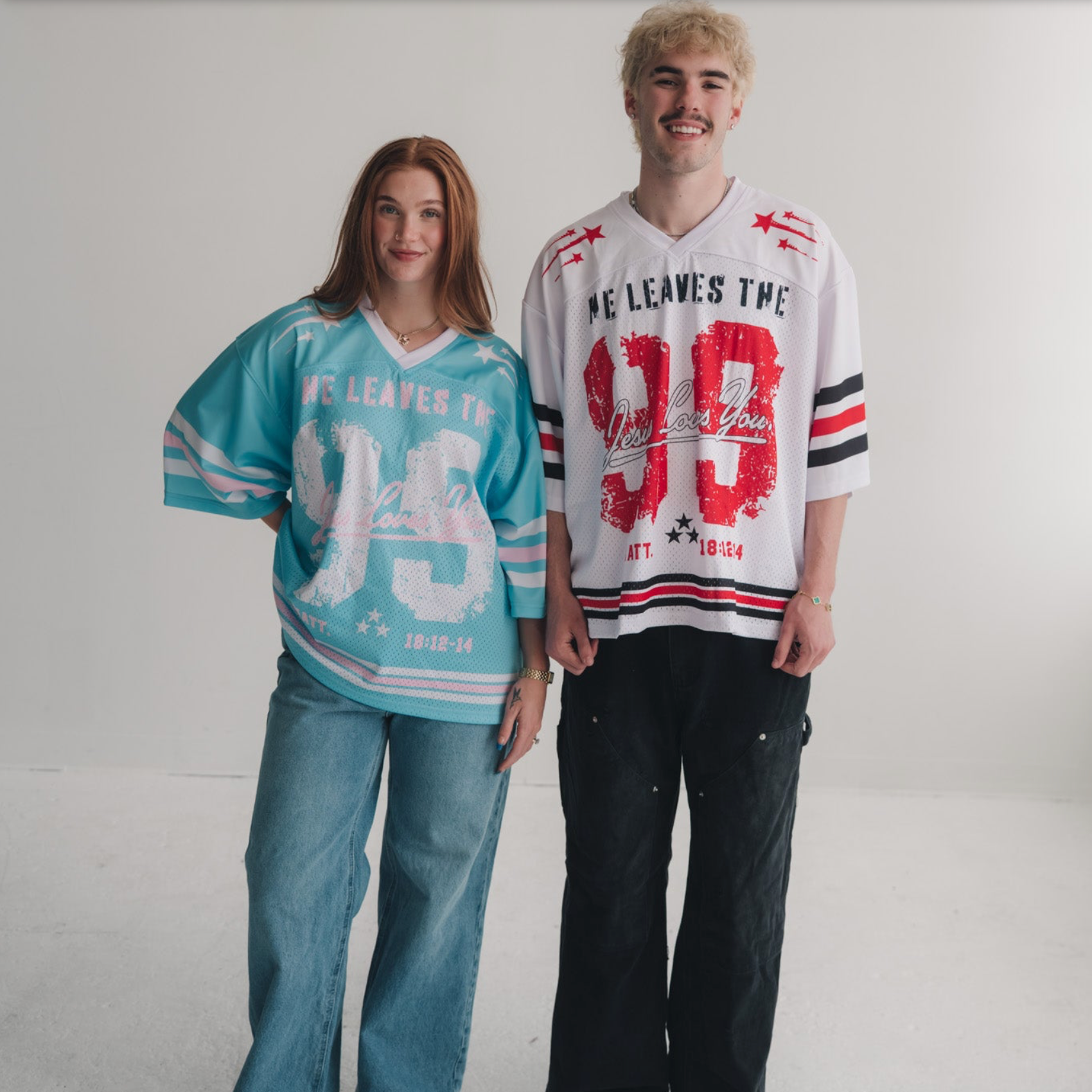 Two people wearing oversized sports jerseys on a plain background