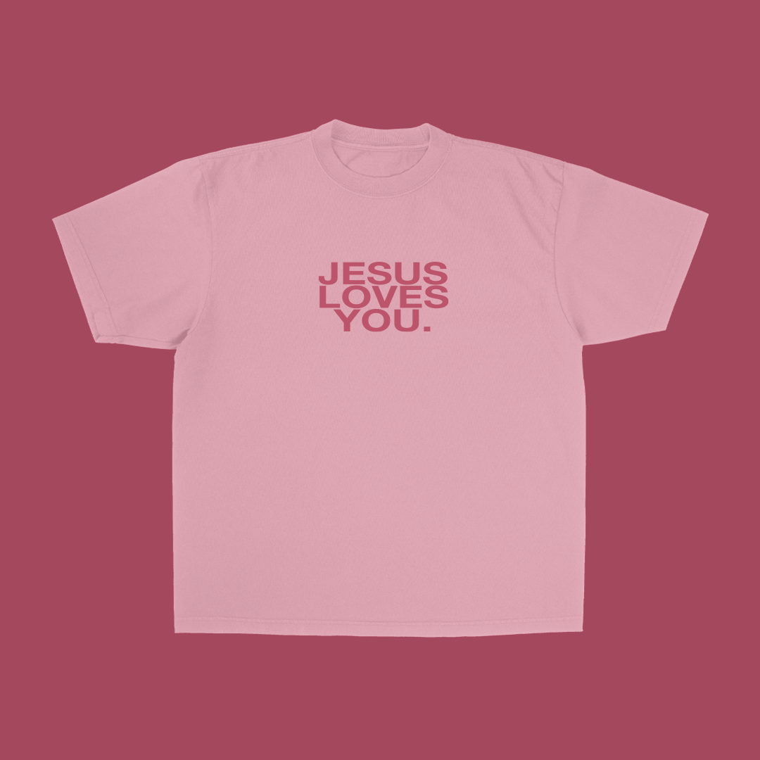 Pink t-shirt with 'Jesus Loves You' text on a pink background