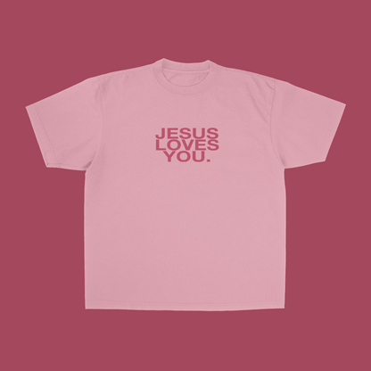 Pink t-shirt with 'Jesus Loves You' text on a pink background