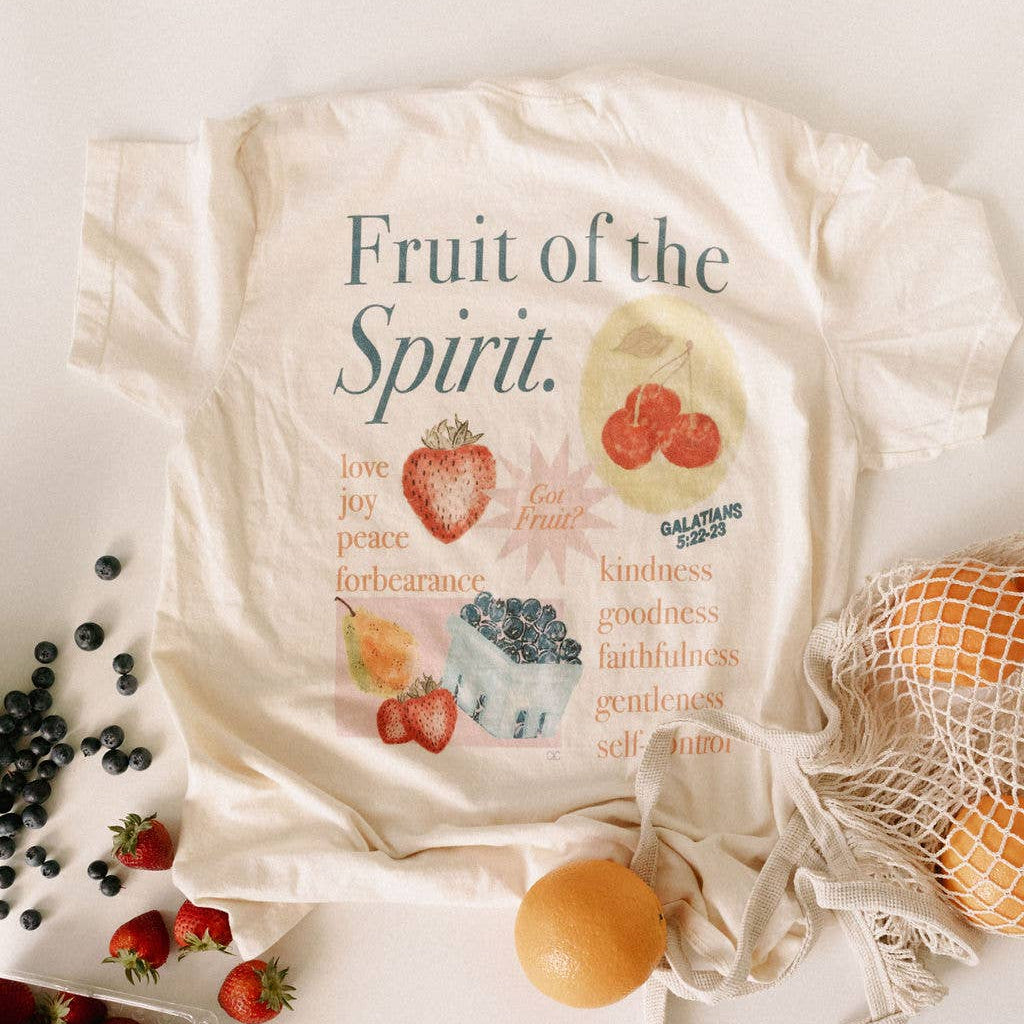 Beige tote bag with 'Fruit of the Spirit' text and illustrations on a light background with fruits.